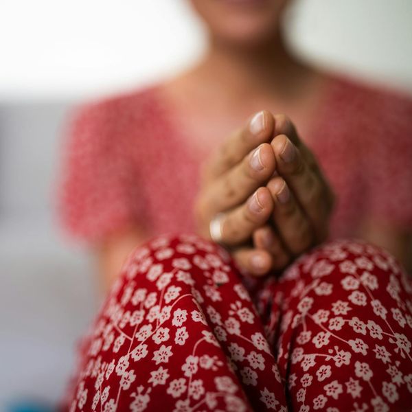 Person meditating peacefully outdoors with a serene natural background.